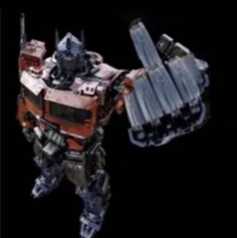 A very blurry photo of Optimus Prime from Rise of the Beast looking up at the camera and flipping it off.